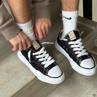 OG Sole sneakers gedragen met witte sokken en casual outfit, contrasterende witte zool springt eruit