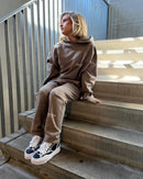 Essentials Desert Taupe tracksuit met beige two-piece en Mihara OG Sole Frayed Black sneakers zittend op trap, clean en edgy