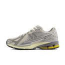 New Balance 1906 Moonbeam Raincloud U1906RDD side view showing silver mesh upper, beige overlays and yellow heel detail.