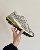 In-hand view of New Balance 1906 Moonbeam Raincloud U1906RDD showing layered mesh panels, N logo and yellow cushioning.