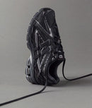 Close-up van het zwarte mesh bovenwerk van de 1906A Black. De technische lagen, gecombineerd met subtiele glans, benadrukken de performance look van deze lifestyle runner.

