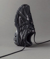 Close-up van het zwarte mesh bovenwerk van de 1906A Black. De technische lagen, gecombineerd met subtiele glans, benadrukken de performance look van deze lifestyle runner.

