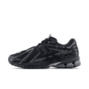 Zijaanzicht van de New Balance 1906A in volledig zwarte colorway. De tonale uitvoering in mesh en synthetische overlays zorgt voor een minimalistische en krachtige uitstraling.

