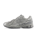 Zijaanzicht van de New Balance 1906A in Concrete en Silver Metallic. Het grijs met zilveren bovenwerk straalt technische precisie uit met een clean, futuristisch karakter.


