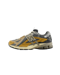 Zijaanzicht van de New Balance 1906A in de kleurstelling Great Plains. De combinatie van aardetinten, off-white mesh en subtiele contrasten geeft deze sneaker een rustige, natuurlijke uitstraling.

