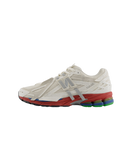 Zijaanzicht van de New Balance 1906A in Sea Salt en Astro Dust. De zachte off-white basis met roze accenten geeft deze sneaker een uitgebalanceerde mix van retro en moderne invloeden.

