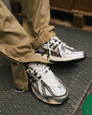 Onderzijde van de New Balance 1906A Tech Explosion met robuuste zool en N-ERGY demping. De felle kleuraccenten in het profiel versterken het futuristische karakter van het model.

