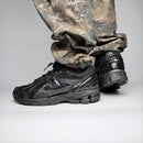 New Balance 1906D Black Leather met originele doos, zwarte veters en lederen upper in detail

