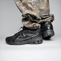 New Balance 1906D Black Leather met originele doos, zwarte veters en lederen upper in detail

