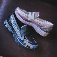 Low light setting met blauwpaars licht op de sneakers, waardoor de reflectieve accenten oplichten