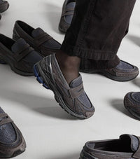 Close-up van het mesh bovenwerk van de New Balance 1906L Magnet. De combinatie van textuur en donkere overlays zorgt voor een diepe, gelaagde look.

