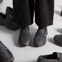 In-hand view van de New Balance 1906L in Magnet kleurstelling. De subtiele glans en het donkere palet maken dit tot een veelzijdige en tijdloze lifestyle runner.

