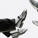 Onderkant van de New Balance 1906L Silver Metallic Black met N-ERGY demping. De zwarte zool met reflecterende tinten biedt een stabiele basis en high-performance look.

