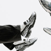 Onderkant van de New Balance 1906L Silver Metallic Black met N-ERGY demping. De zwarte zool met reflecterende tinten biedt een stabiele basis en high-performance look.

