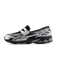 Zijaanzicht van de New Balance 1906L in Silver Metallic Black. De combinatie van glanzend zilver en diepe zwarte accenten geeft deze sneaker een futuristische edge met performance-uitstraling.

