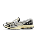 Zijaanzicht van de New Balance 1906L in Silver Metallic en Cream tinten. De combinatie van glanzend zilver en zachte beige tonen geeft deze runner een futuristische maar verfijnde uitstraling.

