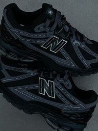 In-hand view van de New Balance 1906R Black Phantom. De tonal black colorway geeft dit model een clean, gestroomlijnd en futuristisch uiterlijk dat past bij elke outfit.

