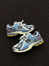 New Balance 1906R Blue Moonbeam met originele doos, zachte mesh upper en extra veters zichtbaar

