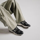 New Balance 1906R Eclipse on-feet met zwarte cargo pants en reflective accents zichtbaar in daglicht

