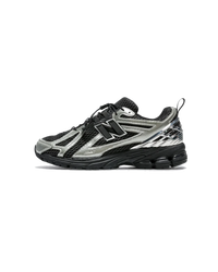 Zijaanzicht van de New Balance 1906R The Basement Night Chrome. De donkere tinten, reflecterende details en subtiele branding zorgen voor een futuristische en exclusieve uitstraling.

