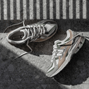 Close-up van de ademende mesh upper van de New Balance M1906NE, met overlays in Flat Taupe en Dark Olivine. De sneaker biedt een stijlvolle mix van retro design en hedendaags materiaalgebruik.

