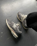 New Balance 2002R Rain Cloud – in-hand shot van de sneaker met zicht op het ruwe suède en het ademende mesh bovenwerk