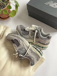 New Balance 2002R Rain Cloud – close-up van de rafelige suède panelen, layered design en ABZORB‑demping in de zool