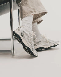 Outfitfoto met de NB 204L gecombineerd met beige trenchcoat en hoge sokken, gericht op vrouwen die styling zoeken voor lente en herfst