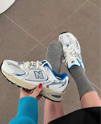 Bovenaanzicht van de New Balance 530 White Blue Oasis met lichtblauwe logo's en dempende zoolconstructie

