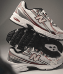 Detail van het New Balance-logo en tonglabel op de 740v2 Mercury Red – stevige padding en klassieke NB branding via Snrkickz