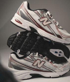 Detail van het New Balance-logo en tonglabel op de 740v2 Mercury Red – stevige padding en klassieke NB branding via Snrkickz