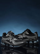 Detail van New Balance ABZORB 2000 Black/Grey – close‑up van mesh textuur, gradient grijze overlays en metallic N‑logo