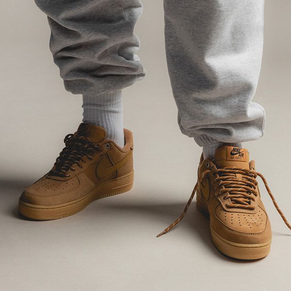 Nike Air Force 1 Low Flax Wheat CJ9179-200 gedragen on-feet met grijze sweatpants, benadrukt streetwear look
