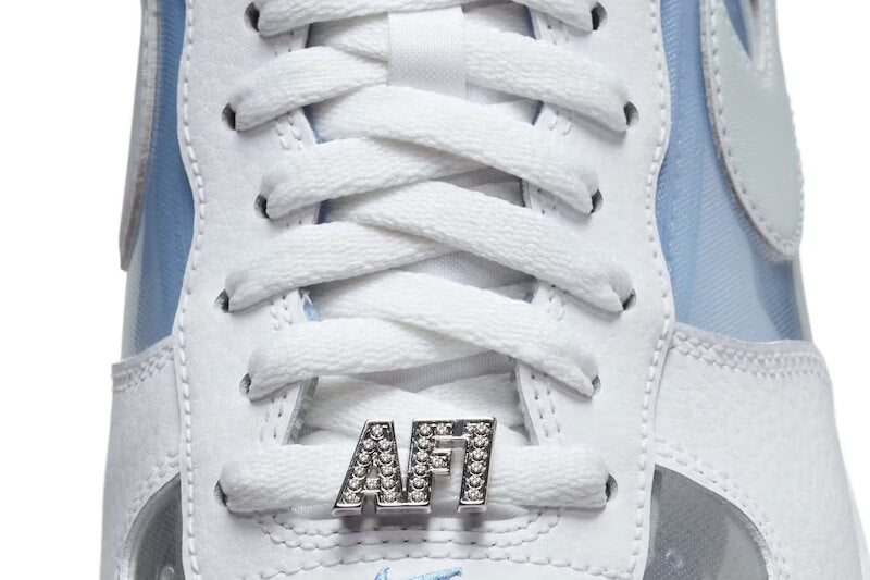 Nike Air Force 1 Low Invisible Woman 2.0 – close-up van transparant materiaal, witte veters en metallic blauwe Swoosh
