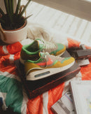 Treeline colorway creatief vastgelegd in een warme setting met suède textuur, pastelgroene tong en vintage vibe tussen planten en boeken