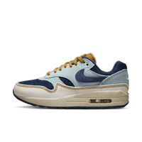 Nike Air Max 1 '87 Denim Aura FQ8900-440 van voren gefotografeerd met zicht op layered denim-panelen, gele veters en zachte off-white zool