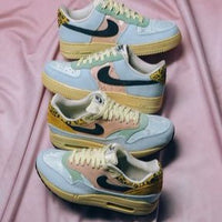 Sneaker zwevend boven effen achtergrond met zicht op de fuzzy overlays, gestikte Swoosh en vintage tonglabel in roze tint