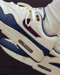 Onderzijde van de Nike Air Max 1 Coconut Milk met zwarte buitenzool, witte midsole en retro Air Max-styling