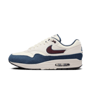 Zijaanzicht van de Nike Air Max 1 Coconut Milk met burgundy swoosh, navy mudguard en offwhite suède overlays