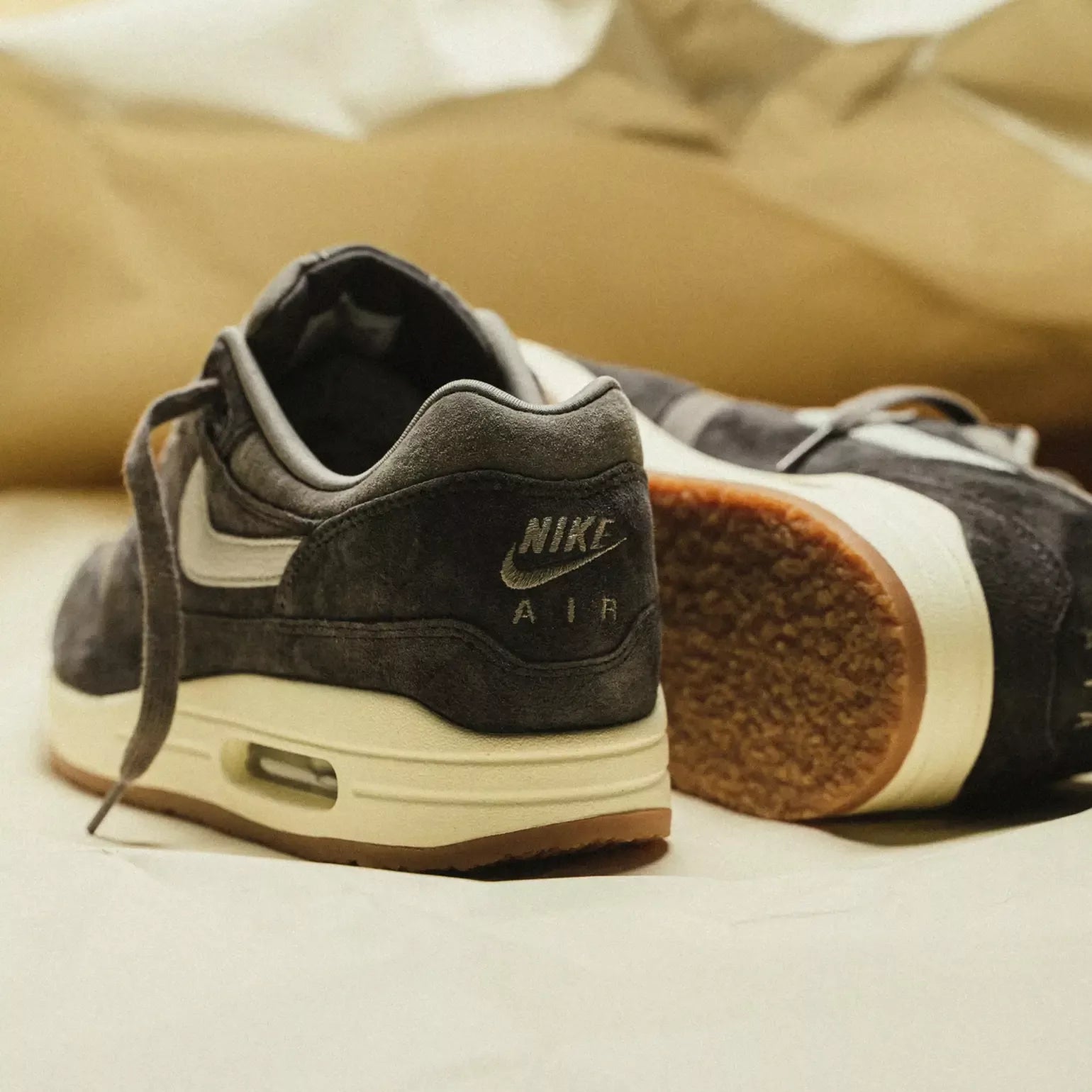 Hielaanzicht benadrukt het geborduurde Nike Air-logo, vintage kleurtoon van de zoolrand en grove textuur van het suède in close-up
