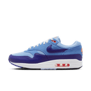Zijkant van de Nike Air Max 1 Psychic Blue met witte mesh, lichtgrijze suède en pastelblauwe mudguard – frisse essential colorway met zomerse feel