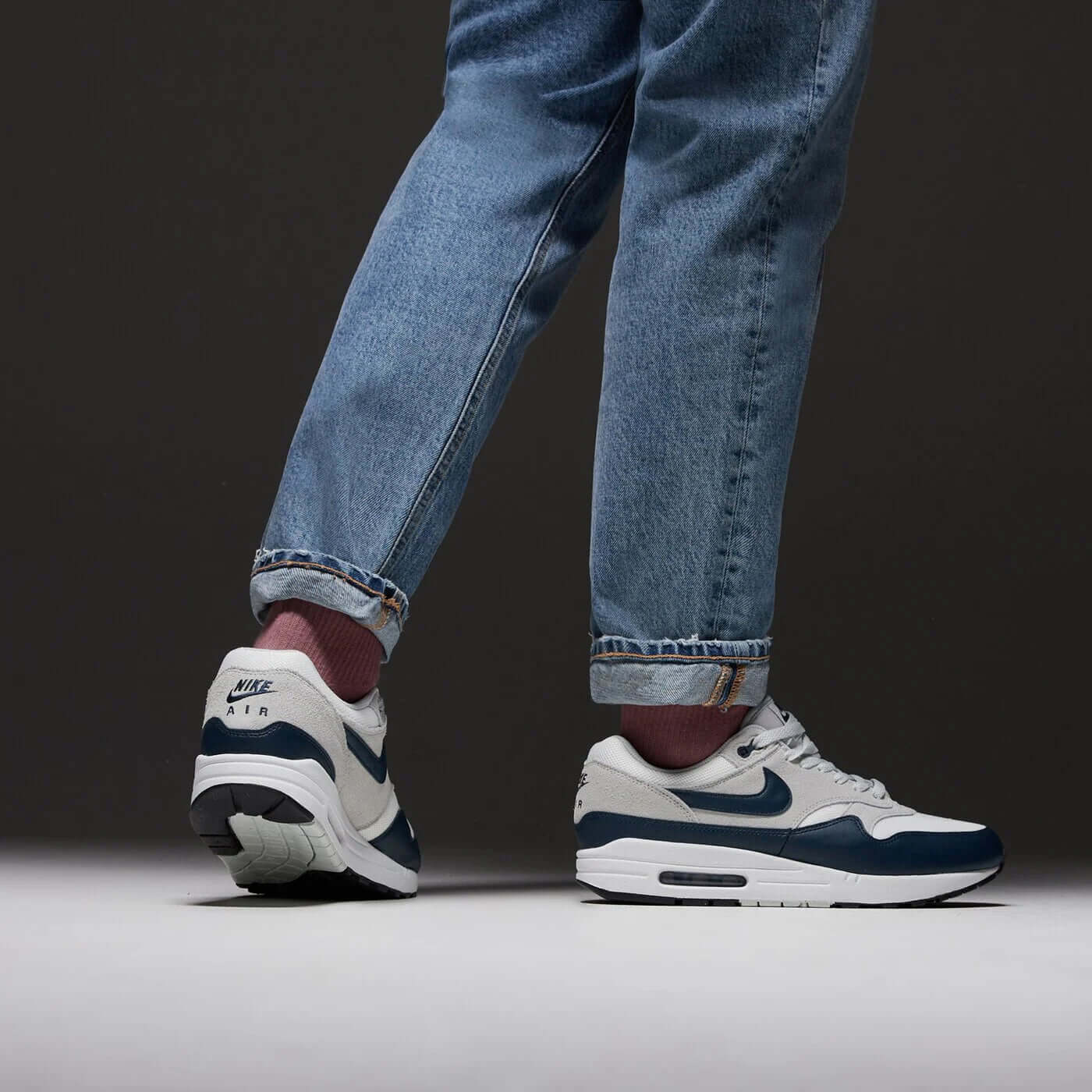Model draagt FZ5808-103 met jeans en witte sokken, sneakers duidelijk zichtbaar door het contrast tussen donkerblauw en gebroken wit