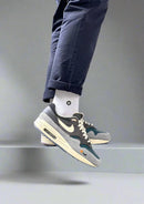 Kasina Air Max 1 Grey on feet met straight fit jeans – luxe materialen en neutrale tinten voor stijlvolle outfits met een cultureel accent

