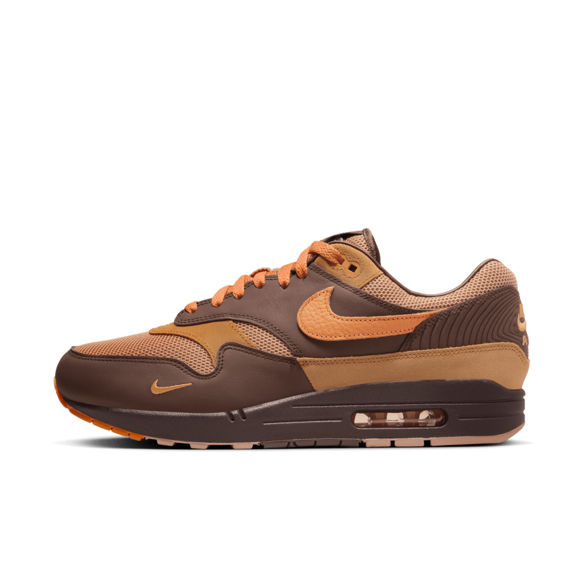 Nike Air Max 1 King’s Day HF7346-200 vanaf de voorzijde met zicht op bruin suède, feloranje tonglabel en tonale veters onder studiolicht