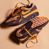 Meerdere paren HF7346-200 op donkere tafel gestyled met zicht op oranje-accenten, gumzool en textuurcombinatie van suède en mesh