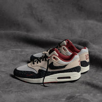 Close-up van shaggy suede overlays op de Air Max 1 Keep Rippin 2.0 met ruwe afwerking en retro details in zwart en ceda