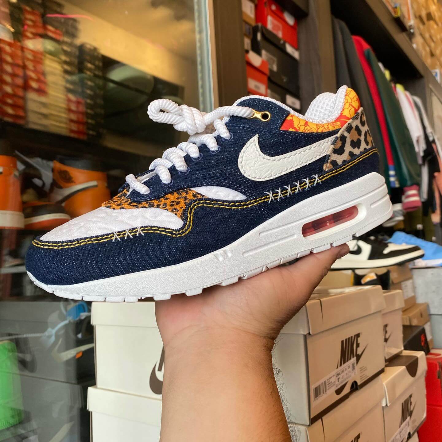 Bovenaanzicht van de Nike Air Max 1 Premium Leopard zicht op tonglogo, veters en denim afwerking via Snrkickz