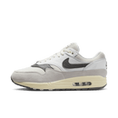 Zijkant van de Nike Air Max 1 Light Bone Iron Grey met suède overlays in lichtgrijs en donkere Swoosh – cleane colorway voor subtiele rotaties