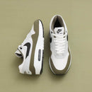 Detail van de olijfgroene mudguard, zwarte Swoosh en witte mesh op de Nike Air Max 1 Medium Olive – premium look via Snrkickz