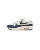 Studiozijaanzicht van de Air Max 1 Obsidian Rugged LX met contrasterende materialen, off-white basistonen en donkerblauwe Swoosh op cleane achtergrond